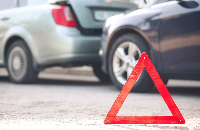 Emergency stop sign near broken cars after accident on road